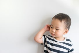 Little baby boy has earache and tugs at his ear, in a story about how to prevent ear infections in k...