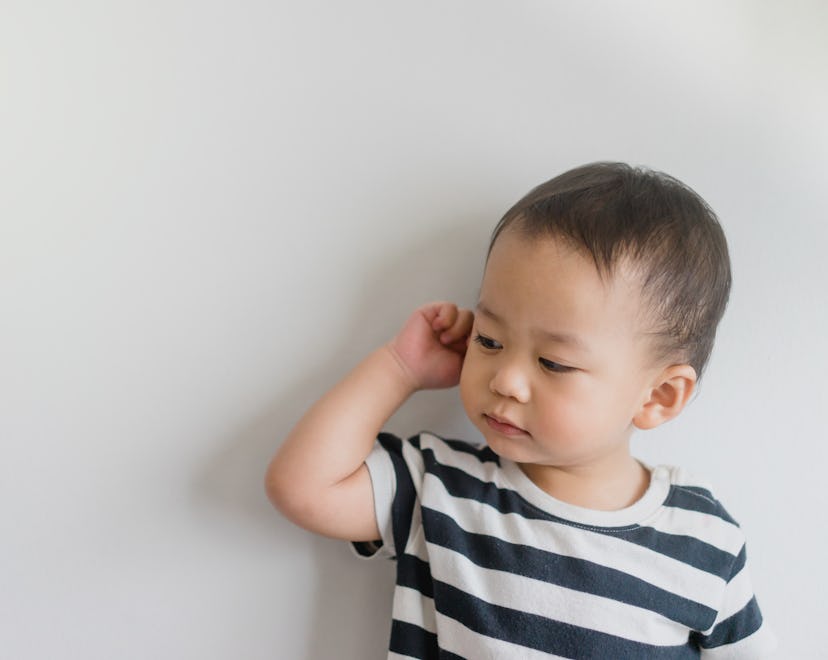 Little baby boy has earache and tugs at his ear, in a story about how to prevent ear infections in k...