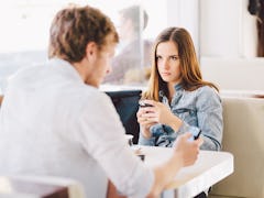 Young man talking on phone ignoring angry mad millennial girlfriend