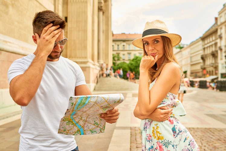 A beautiful young woman upset to her boyfriend who is looking at a map for a way at the St. Stephen’...