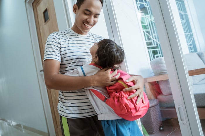 happy asian kindergarten student embrace her dad before going to school