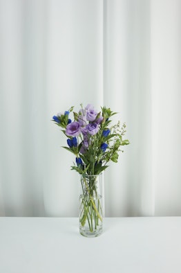 Purple Lisianthus, gentian, solidaster, pittosporum in a vase