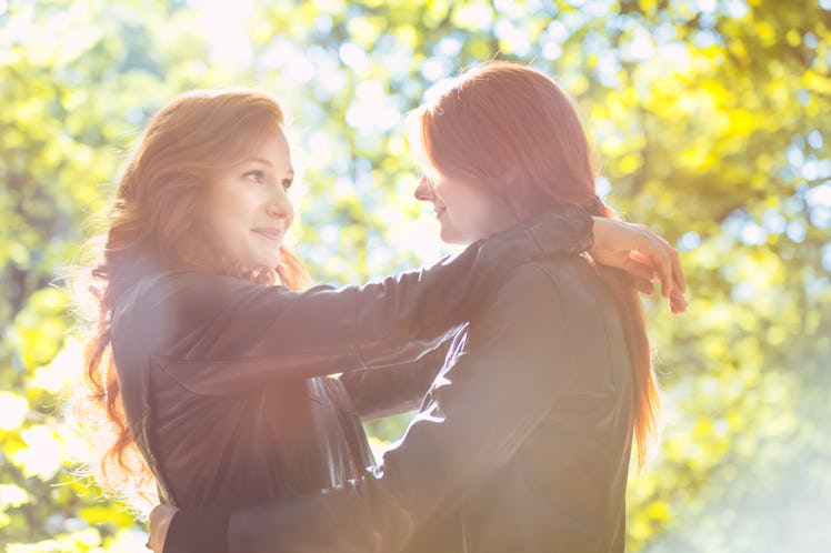 Happy, red-haired best friends hugging in the park during autumn weather