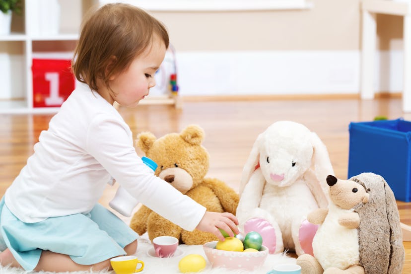 Toddler girl playing with her stuffed animals in her house