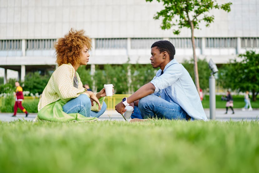 African american hipster girl sitting with boyfriend and communicating about relationship.Two friend...