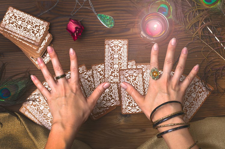 Fortune teller female hands and tarot cards on wooden table. Fortune teller.