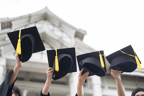 Graduation day. Many hand holding Row of graduation hats on Sky background. Happiness feeling, Comme...
