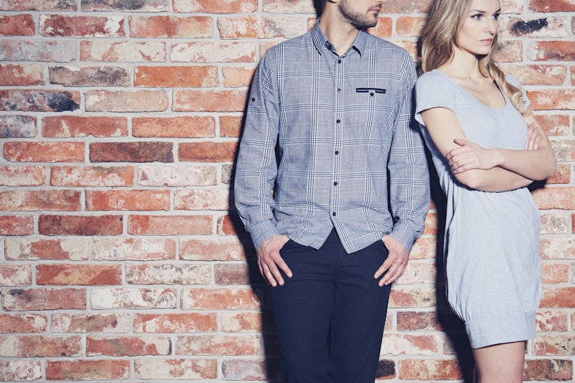 Angry young woman standing next to her boyfriend