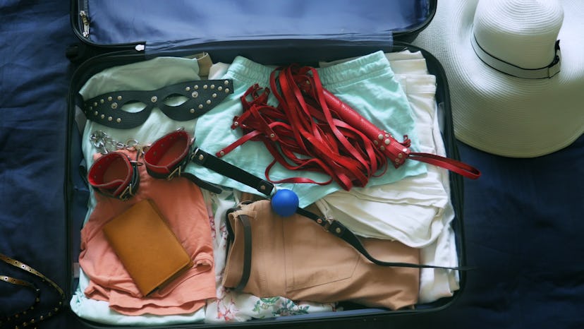 The concept of sex tourism. close-up, a woman collects a suitcase and puts into it the BDSM device.