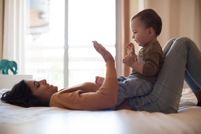 Young mother playing with her baby at home