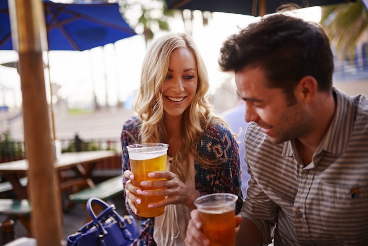 romantic couple drinking beer at outdoor restaurant