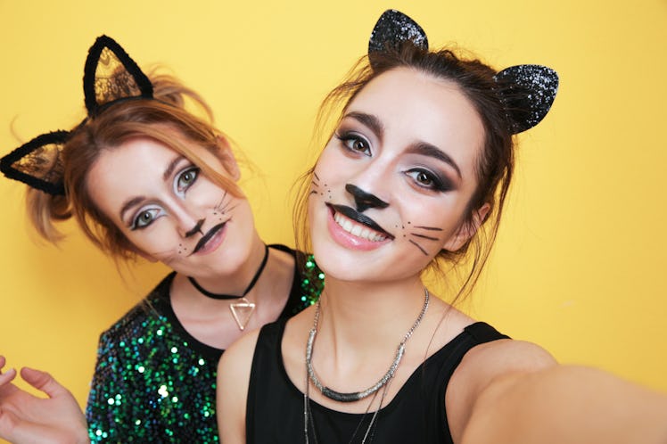 Beautiful young women with cat makeup and ears as their Halloween eye makeup