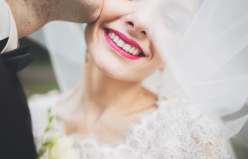 Kissing wedding couple in spring nature close-up portrait