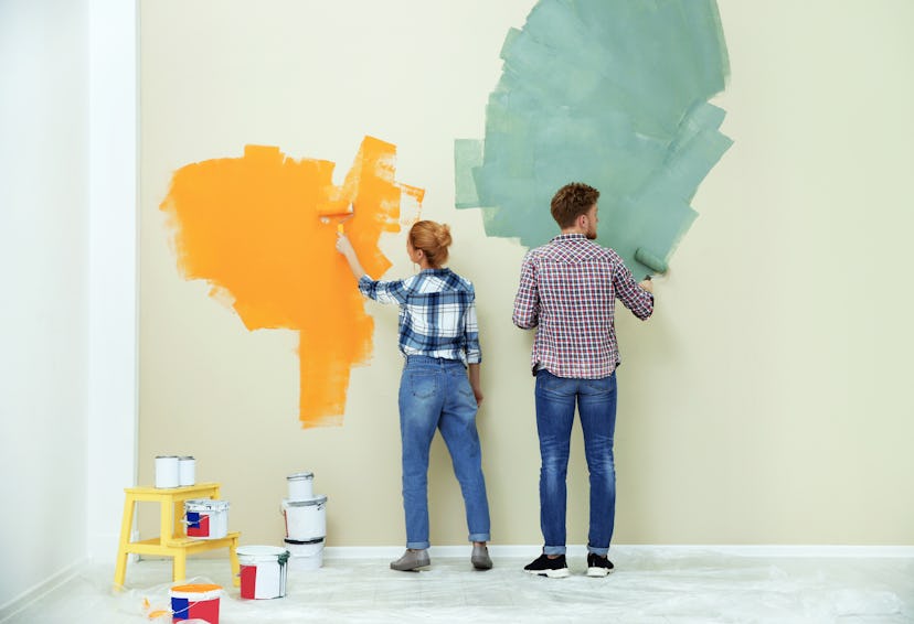 Young couple painting wall indoors. Home repair