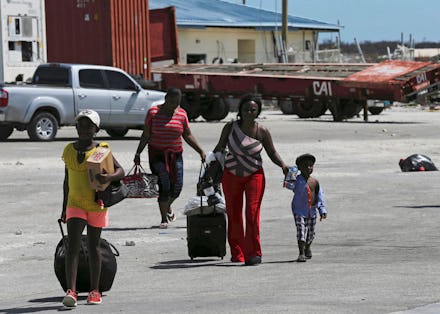 Evacuees carry their belongings as they walk to a ferry to depart for Nassau in the aftermath of Hur...