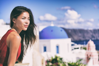 Luxury Europe cruise travel vacation Santorini woman looking at view. Tourist Asian girl relaxing at...