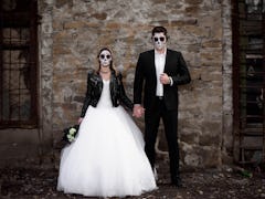 Halloween couple. Dressed in wedding clothes romantic zombie couple. Halloween concept. Fashion phot...