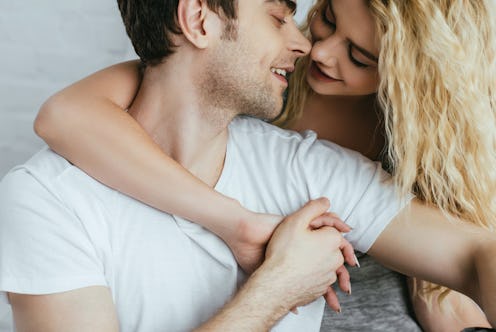 happy handsome man holding hands with blonde cheerful girlfriend