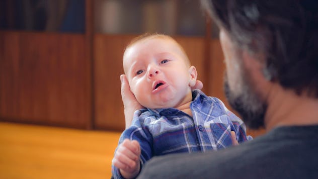 Handsome man with beard holding son. Crying baby in father s arms. Newborn with dad.