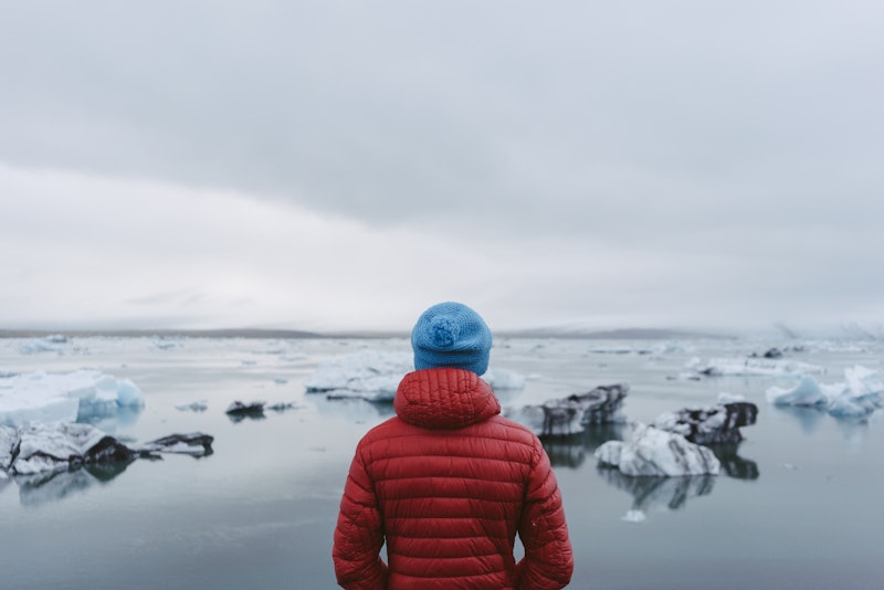 Man standing on the shore of a glacier lagoon.