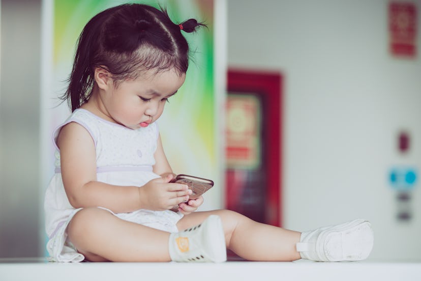 Little baby girl playing smartphone cause ADHD, 1-2 year old
