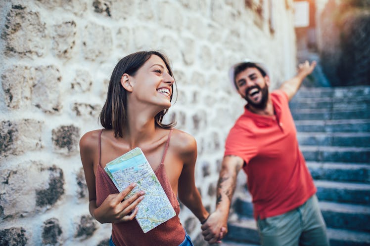 Traveling couple of tourists walking around old town. Vacation, summer, holiday, tourism: concept.