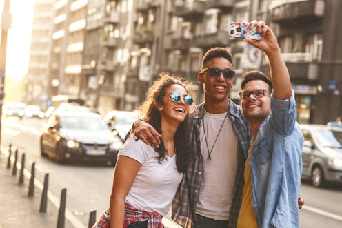 Group of friends hangout at the city street.They embrace each other and doing selfie.