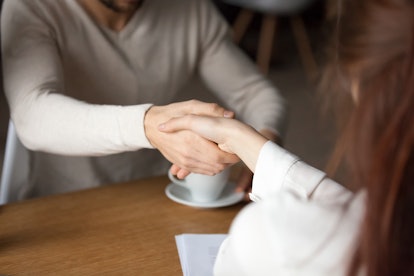Close up of husband shake hand of broker closing deal about house purchase meeting out in café, man ...