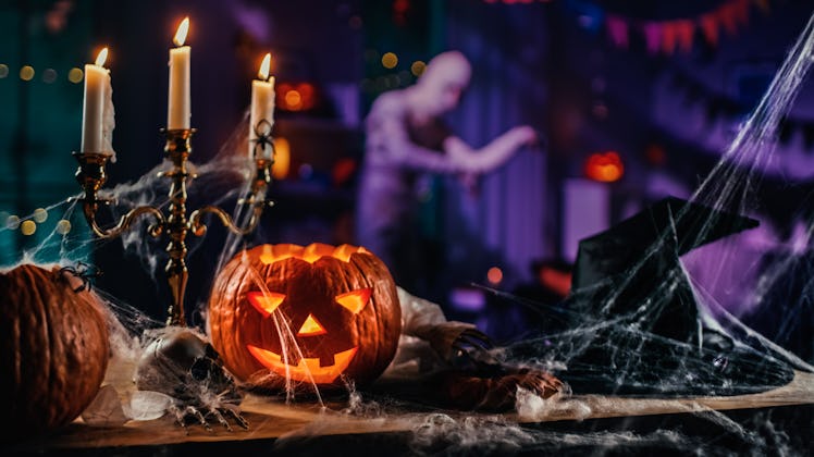 Halloween Still Life Colorful Theme: Scary Decorated Dark Room with Table Covered in Spider Webs, Bu...