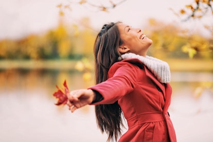 Autumn woman happy smiling feeling free in fall nature. Nature people beauty landscape. Girl by the ...