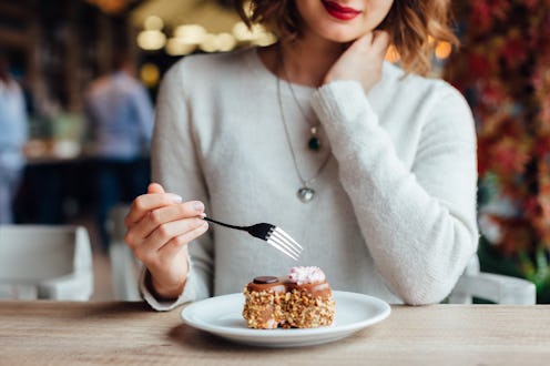 Closeup of woman eating chocolate cake in a cafe