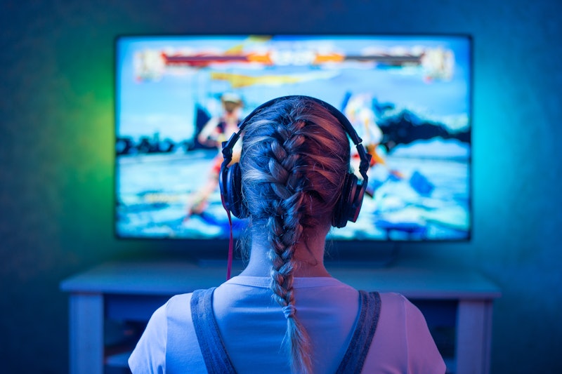 A girl is a gamer or a streamer in front of a television playing.It is possible to use as a backgrou...