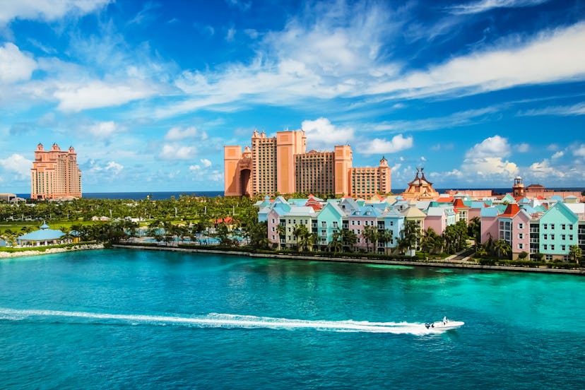 Beautiful scene of speed boat, ocean, colorful houses and a hotel in Nassau, Bahamas on a summer sun...