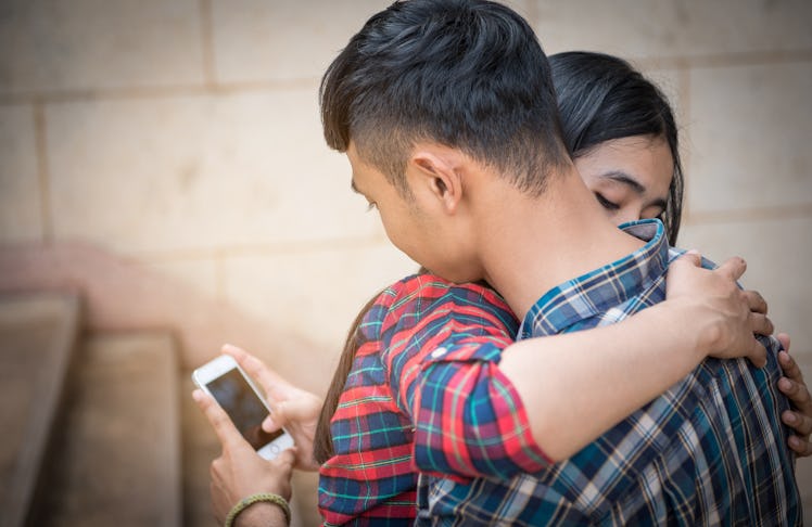 Young man embraces a lover. With a phone