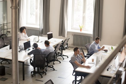 Top view of diverse people working together on computer performing daily routine tasks in coworking ...