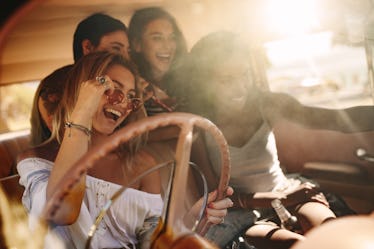 Friends on road trip posing for the selfie inside the car. Group of young women enjoying on the road...