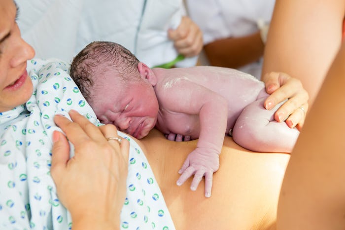 Happy mom, having her baby skin to skin first seconds after birth, happiness family concept