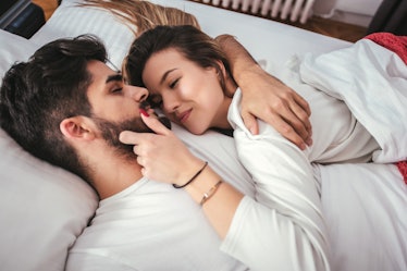 Young loving couple in the bed - people, family, bedtime and happiness concept
