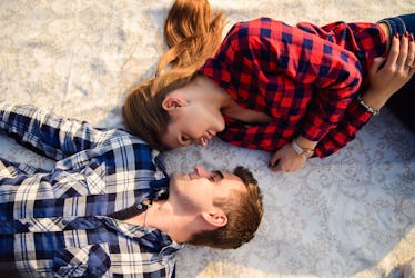 Stylish young couple in shirts and jeans while walking along the lake shore. A beautiful attractive ...