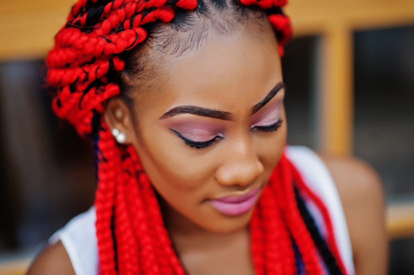 Fashionable african american girl at pink pants and red dreads posed outdoor.