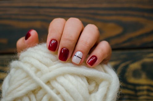 Luxury short manicure Burgundy on a black background. cozy autumn nails.