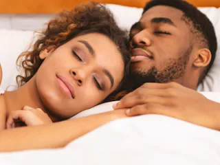 True love. Black couple sleeping together, cuddling in bed, closeup