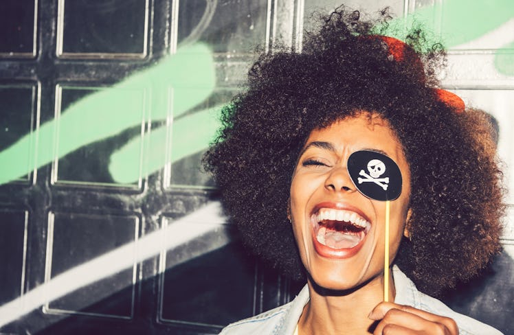 Beautiful young black woman having fun with a fake party pirate costume