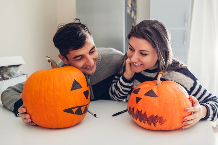 A couple making jack-o'-lanterns for Halloween may be in need of some cute pumpkin carving captions ...
