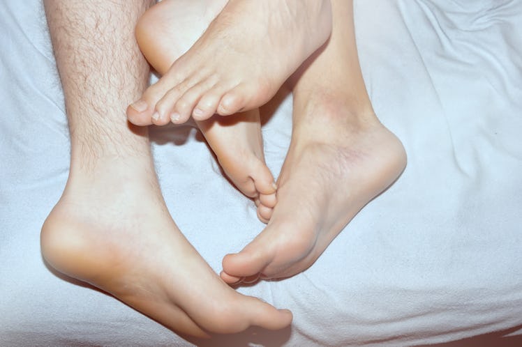 Couple on the bed, crossed legs. Love and relationships