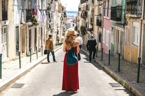 Young travel woman is walking on the beautiful old cozy street of Lisbon in Portugal