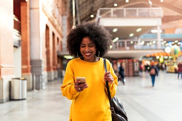 Beautiful woman using mobile in the train station. Communication concept