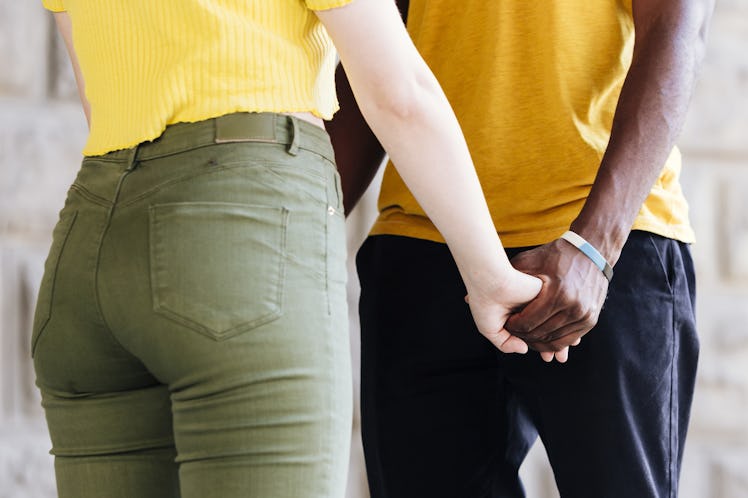 Medium shot of interracial couple holding hands