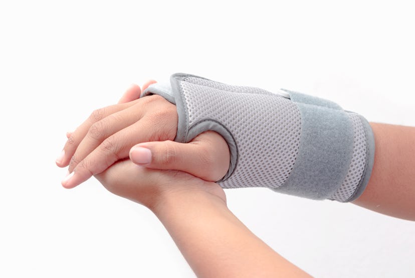 Woman's hand with wrist brace on white background