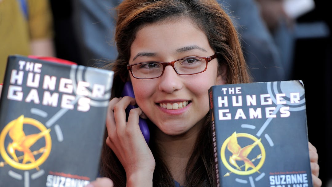 A Hunger Game fan holds up a copy of the Hunger Games book at the world premiere of "The Hunger Game...